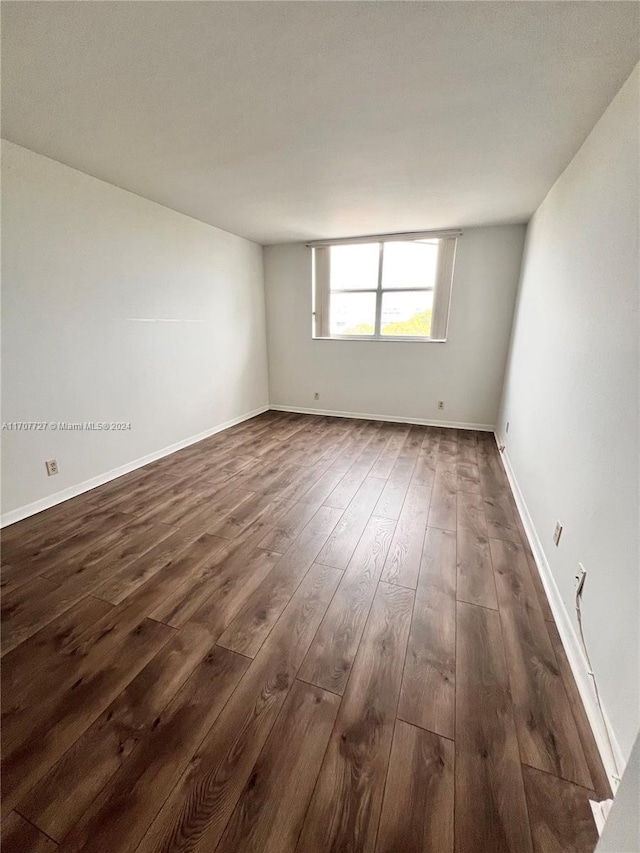 spare room with dark wood-type flooring