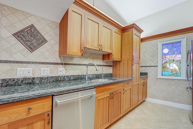 kitchen featuring light tile patterned flooring, stainless steel dishwasher, dark stone countertops, and sink