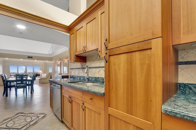 kitchen featuring sink, stainless steel dishwasher, dark stone countertops, decorative backsplash, and light tile patterned floors