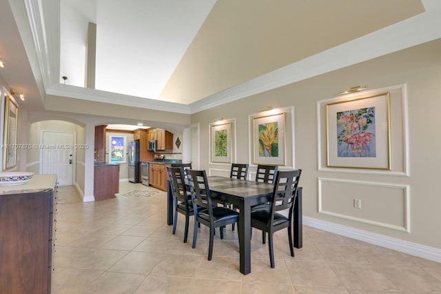 dining space featuring light tile patterned floors and a high ceiling