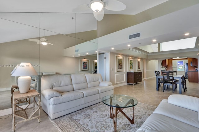 tiled living room featuring ceiling fan and high vaulted ceiling