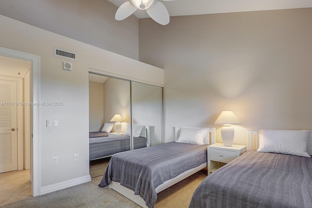 bedroom with ceiling fan, light colored carpet, and a closet