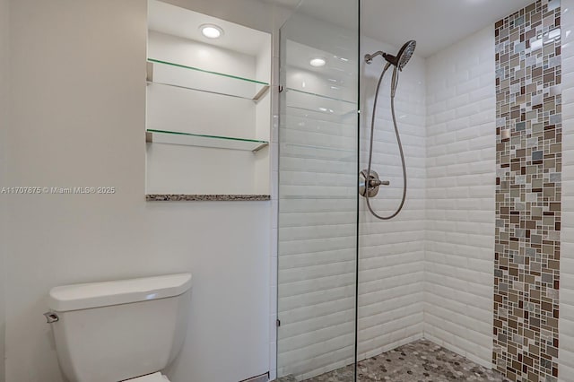 bathroom with tiled shower and toilet