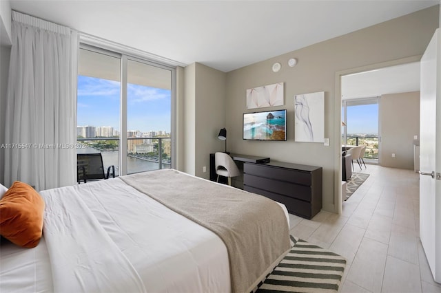 bedroom with multiple windows, access to outside, and a wall of windows