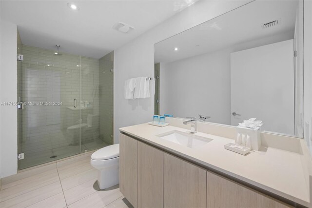 bathroom with tile patterned flooring, vanity, an enclosed shower, and toilet