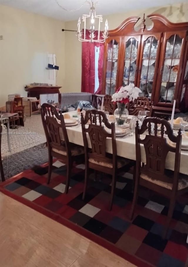 dining space with hardwood / wood-style flooring and a notable chandelier