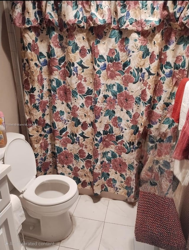 bathroom featuring tile patterned flooring, vanity, and toilet