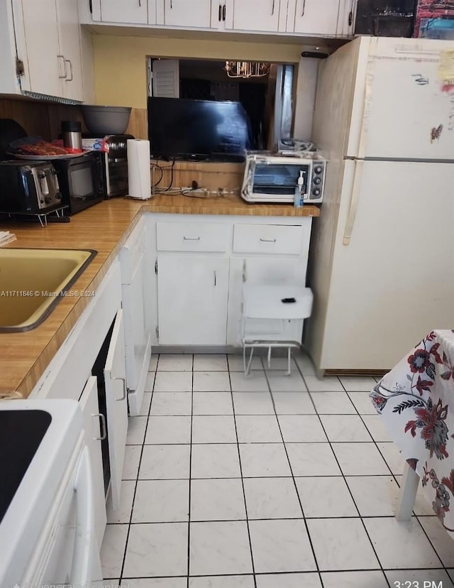 kitchen with white cabinetry, sink, washer / clothes dryer, white appliances, and light tile patterned flooring