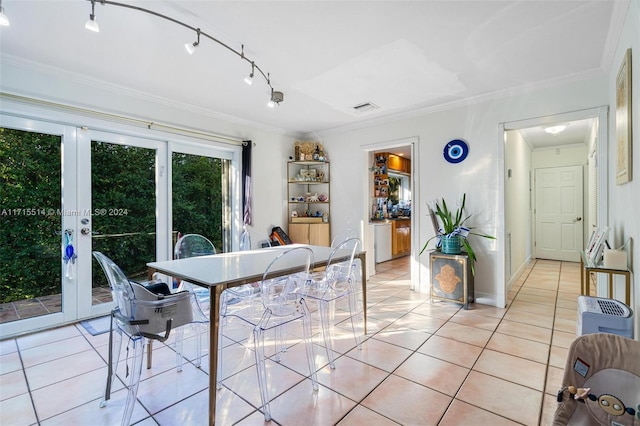 dining space with light tile patterned floors and crown molding