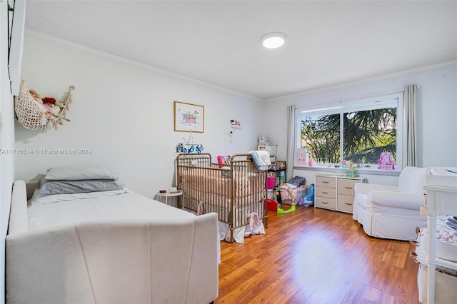 bedroom with hardwood / wood-style flooring and ornamental molding