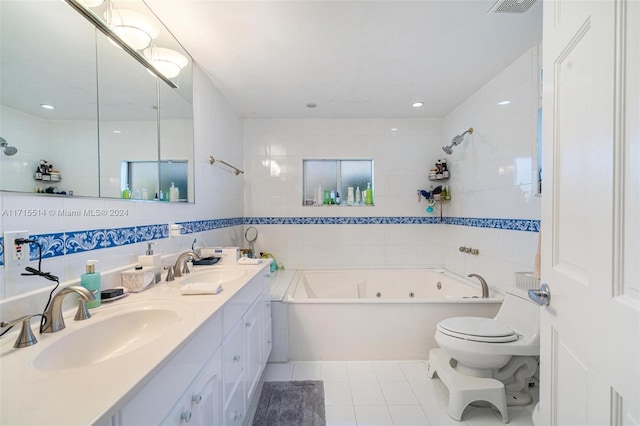 bathroom with a washtub, vanity, tile walls, tile patterned flooring, and toilet