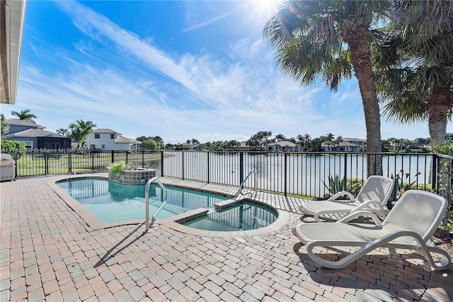 view of swimming pool featuring a patio, a water view, and an in ground hot tub