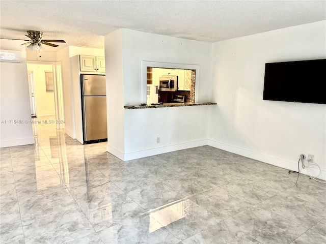 unfurnished living room with a textured ceiling and ceiling fan