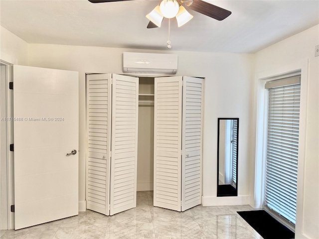 unfurnished bedroom with a closet, an AC wall unit, and ceiling fan