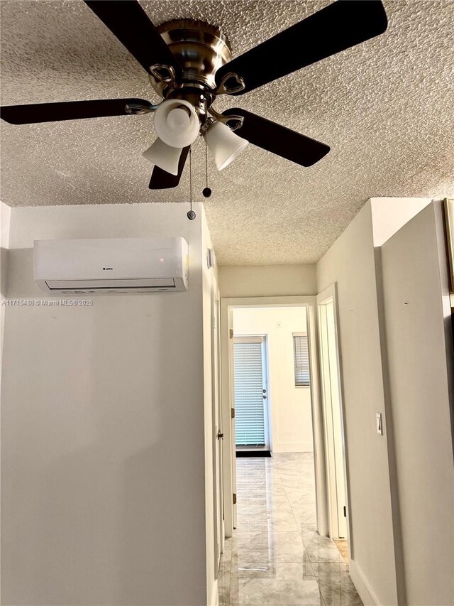 interior space featuring ceiling fan, an AC wall unit, stainless steel fridge, a textured ceiling, and cream cabinetry