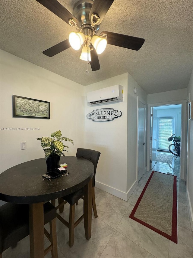 dining room featuring a wall mounted AC, light tile patterned floors, a textured ceiling, and ceiling fan