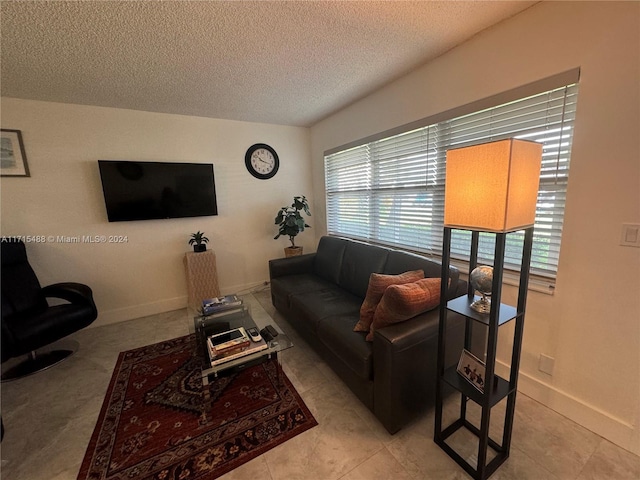 tiled living room featuring plenty of natural light and a textured ceiling