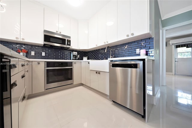 kitchen with decorative backsplash, white cabinetry, and appliances with stainless steel finishes