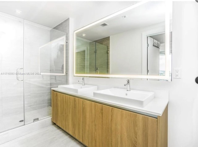 bathroom with vanity and a shower with shower door