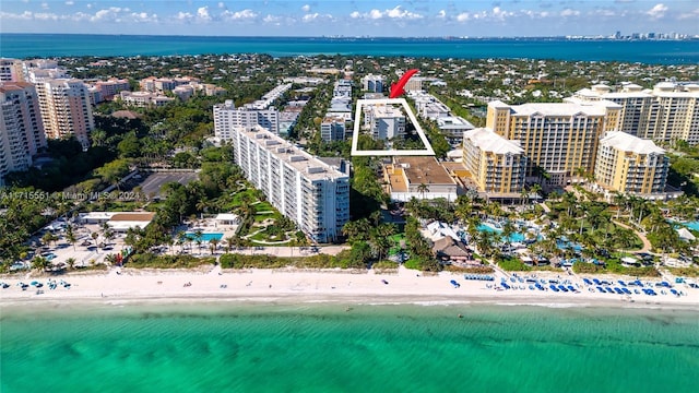 drone / aerial view featuring a water view and a view of the beach