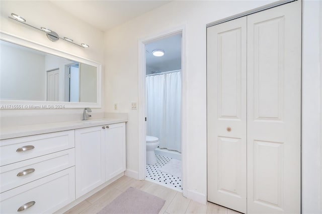 bathroom with toilet, vanity, and walk in shower