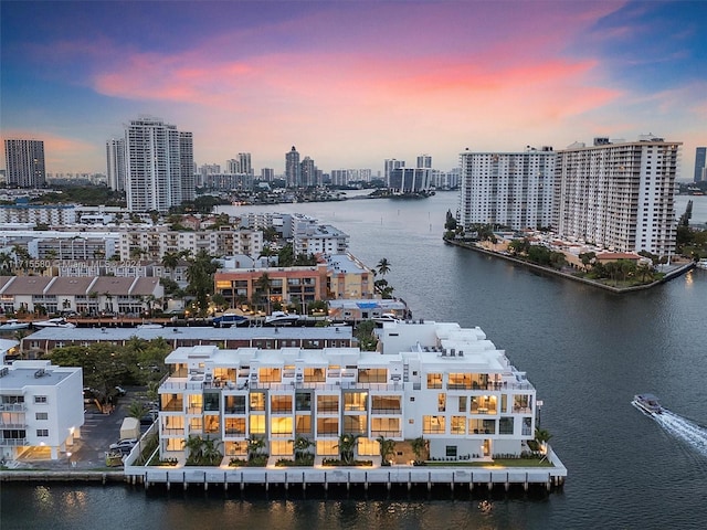 aerial view at dusk featuring a water view