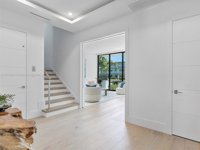 entrance foyer featuring light hardwood / wood-style floors and a wall of windows