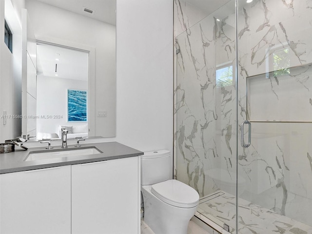 bathroom featuring vanity, toilet, and a shower with shower door