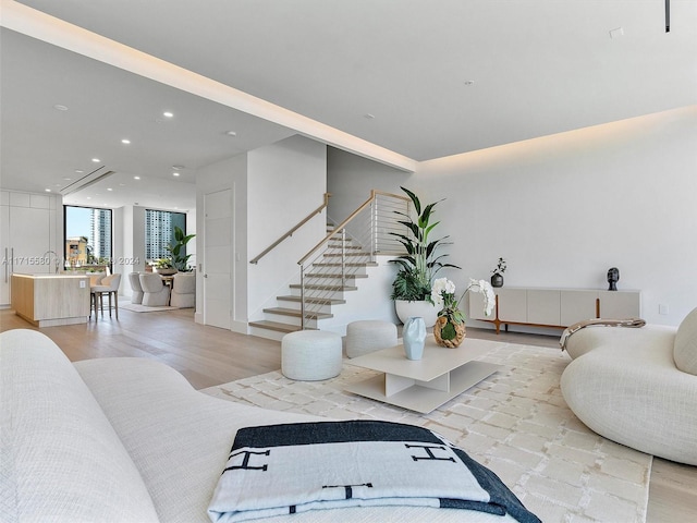 living room featuring a wall of windows and light wood-type flooring