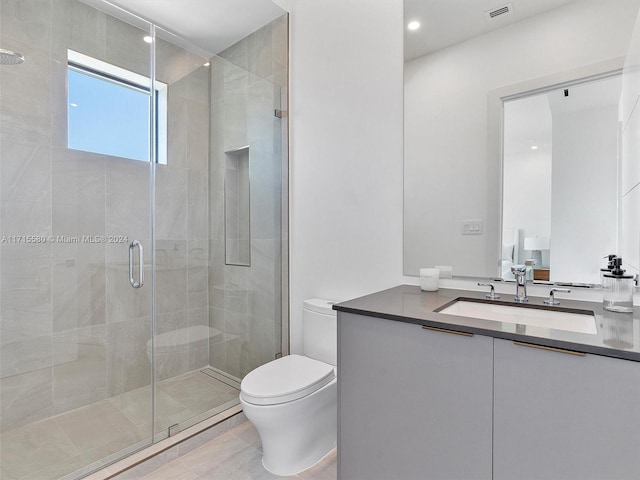 bathroom featuring vanity, toilet, and a shower with door