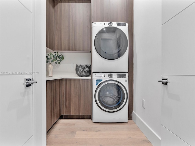 washroom with stacked washer and dryer and light hardwood / wood-style floors