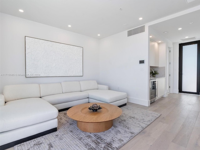 living room with light hardwood / wood-style floors and wine cooler