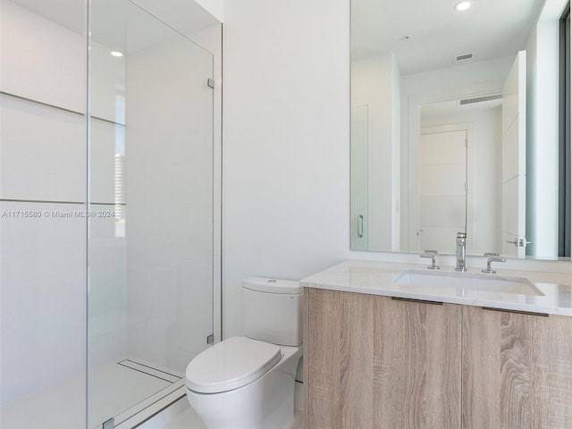 bathroom featuring tiled shower, vanity, and toilet