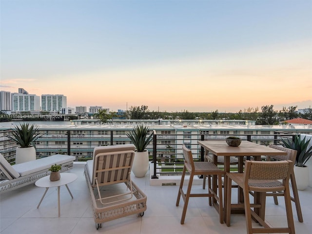 patio terrace at dusk featuring a balcony