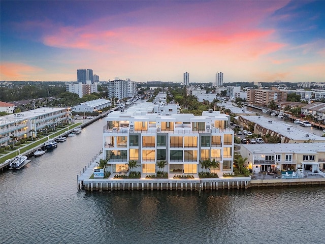 aerial view at dusk featuring a water view