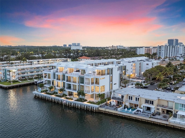 aerial view at dusk featuring a water view