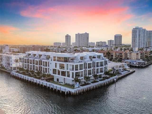 aerial view at dusk featuring a water view