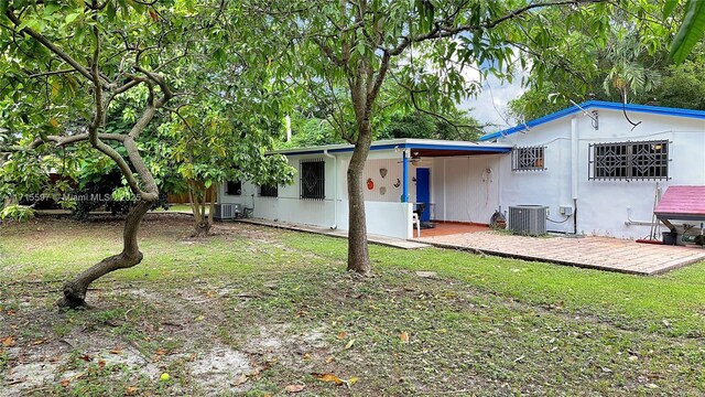 back of property with central AC unit and a patio area