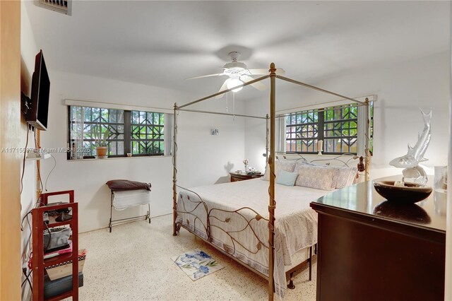 bedroom with ceiling fan and multiple windows