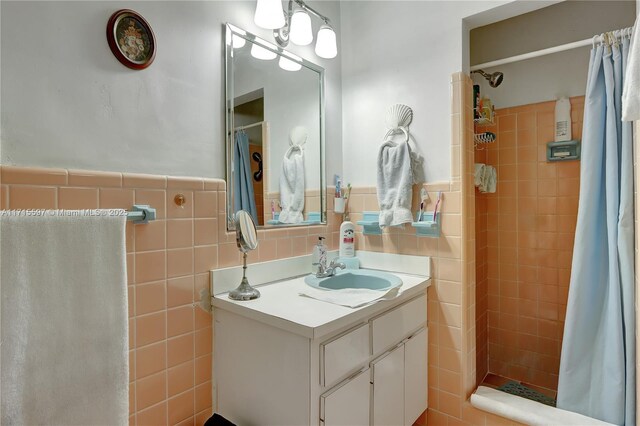 bathroom with a shower with curtain, vanity, and tile walls