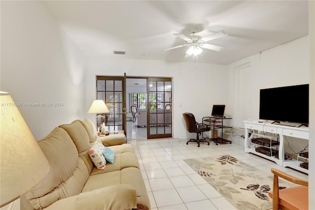 tiled living room with ceiling fan and french doors