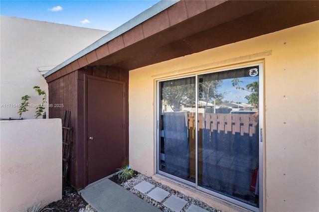 entrance to property featuring stucco siding