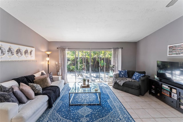 living area with vaulted ceiling, light tile patterned floors, and a textured ceiling