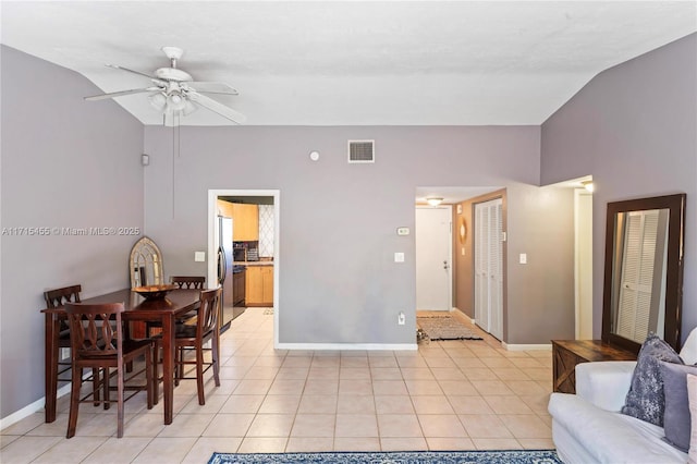 dining room featuring light tile patterned floors, lofted ceiling, visible vents, ceiling fan, and baseboards