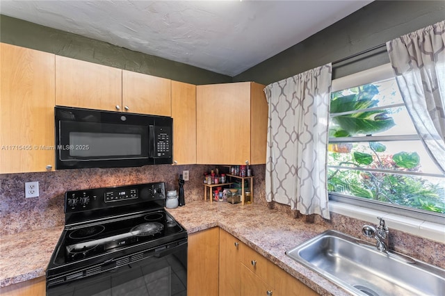 kitchen featuring a sink, light countertops, light brown cabinetry, black appliances, and backsplash