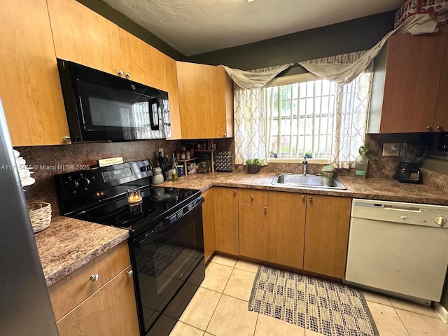 kitchen with black appliances, tasteful backsplash, light tile patterned floors, and a sink