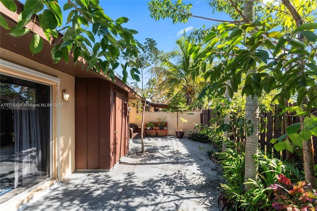 view of property exterior featuring a patio area, fence, and stucco siding