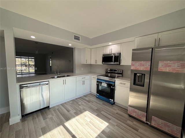 kitchen featuring white cabinetry, sink, light hardwood / wood-style flooring, and appliances with stainless steel finishes