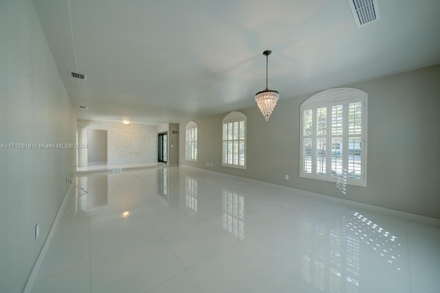 unfurnished room featuring tile patterned flooring and a chandelier