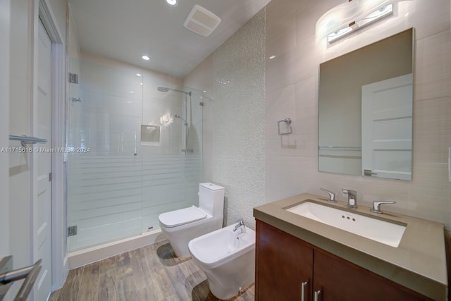 bathroom with hardwood / wood-style floors, a shower with door, tile walls, and a bidet